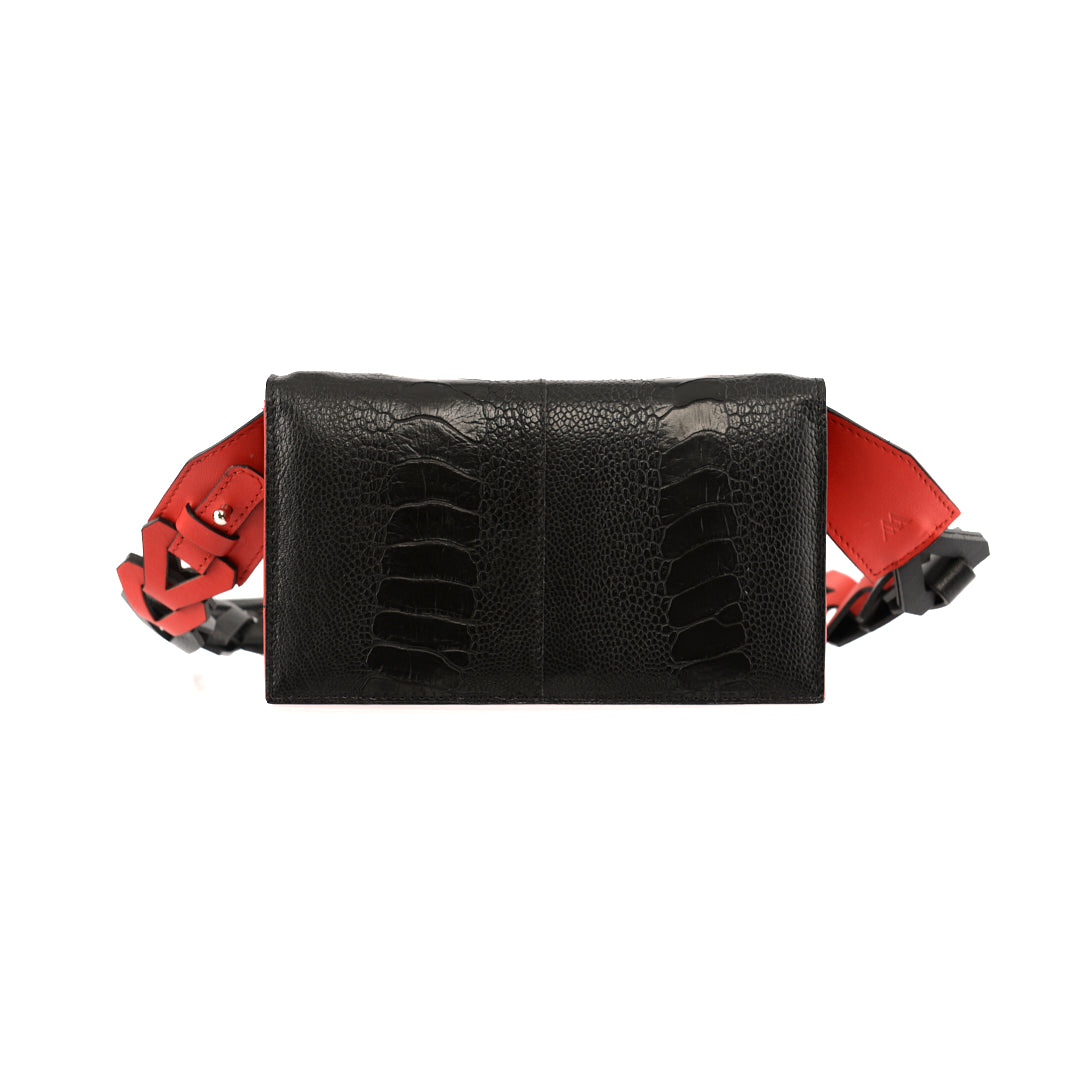 A black leather purse with red details on the straps, featuring a compact design and a removable strap.