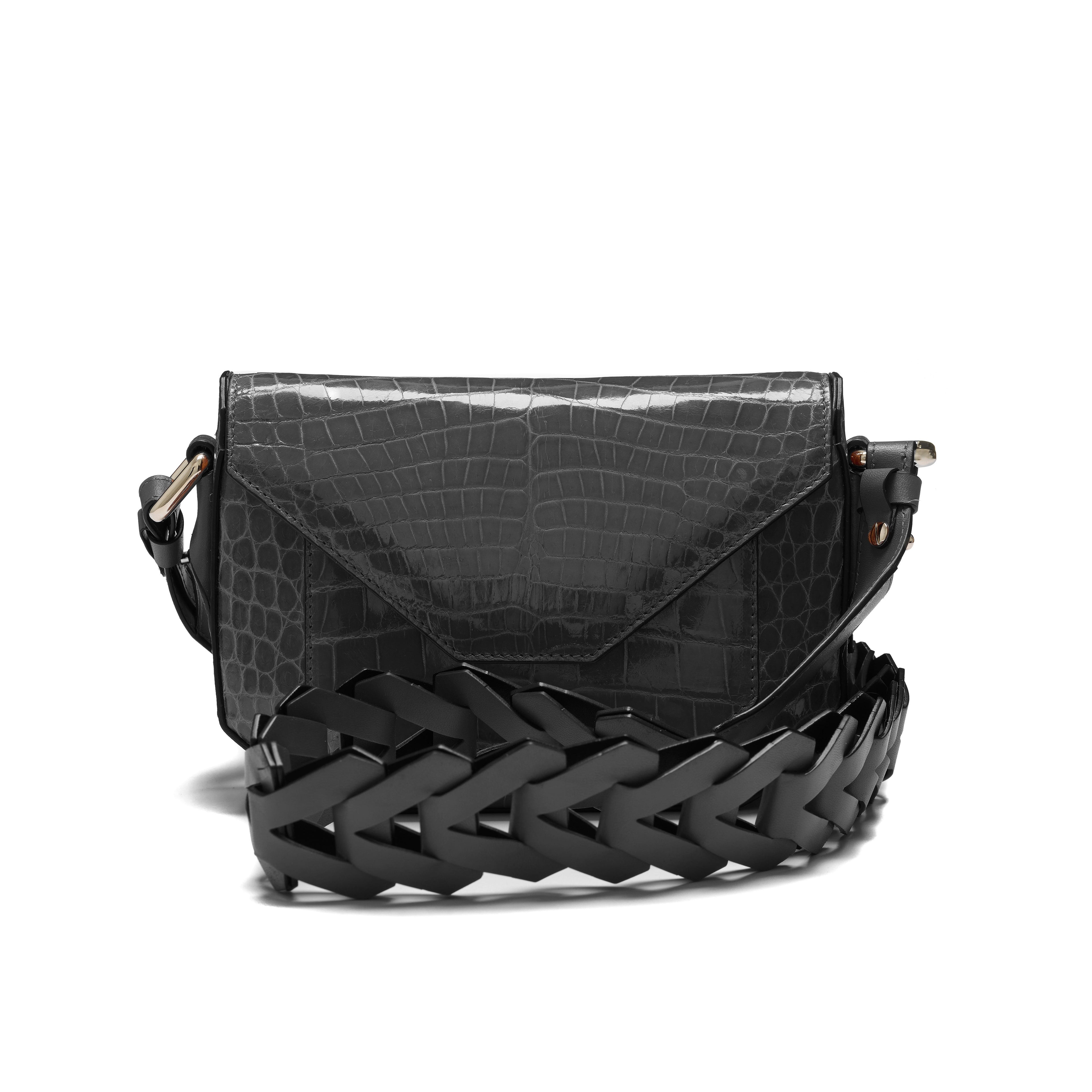 Black textured handbag with a braided black strap on a white background