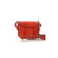 A red handbag with a structured and small silhouette, featuring a crocodile pattern, a magnetic top closure, and a detachable strap.