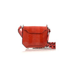 A red handbag with a structured and small silhouette, featuring a crocodile pattern, a magnetic top closure, and a detachable strap.