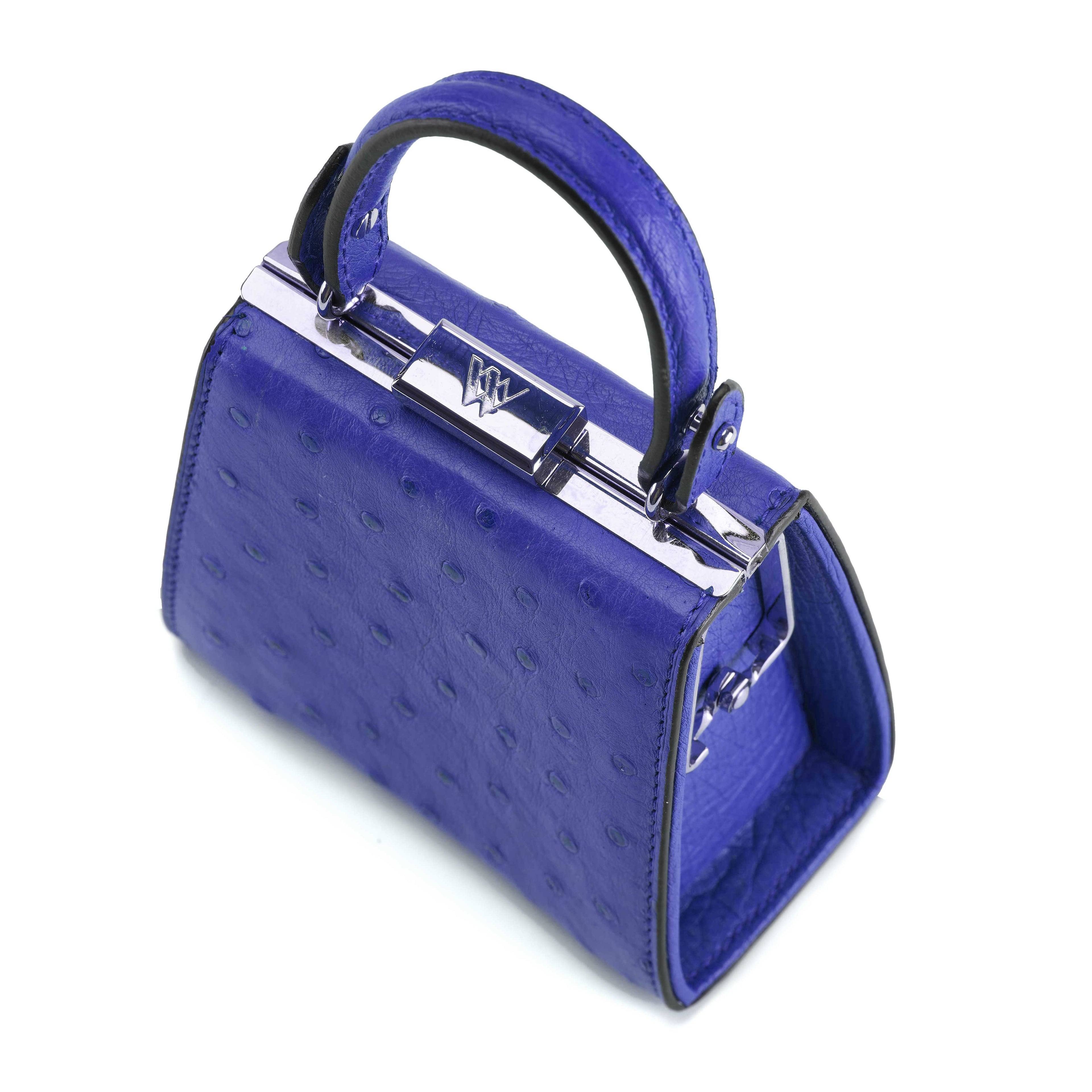 Blue handbag with a textured surface and silver clasp on a white background