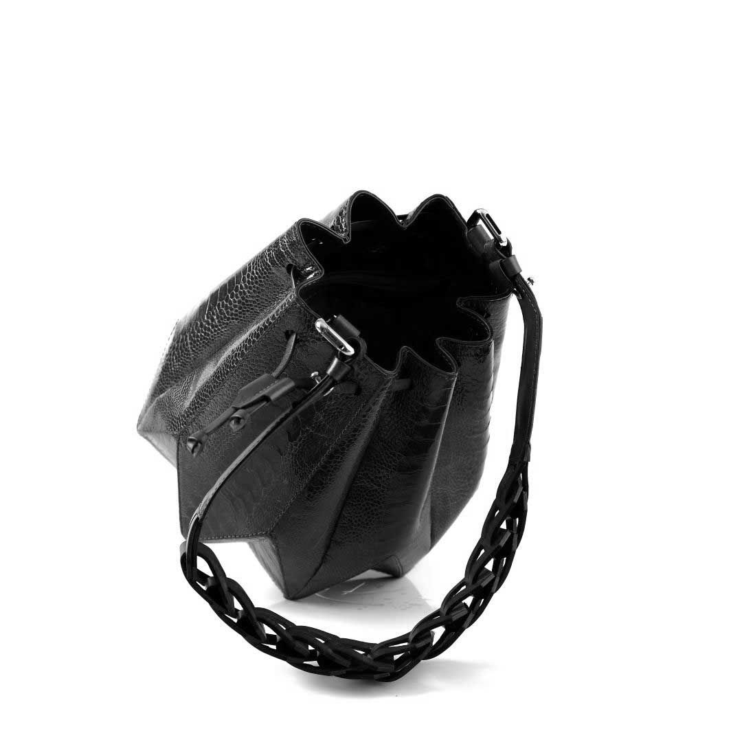 Black leather handbag with braided handle on a white background