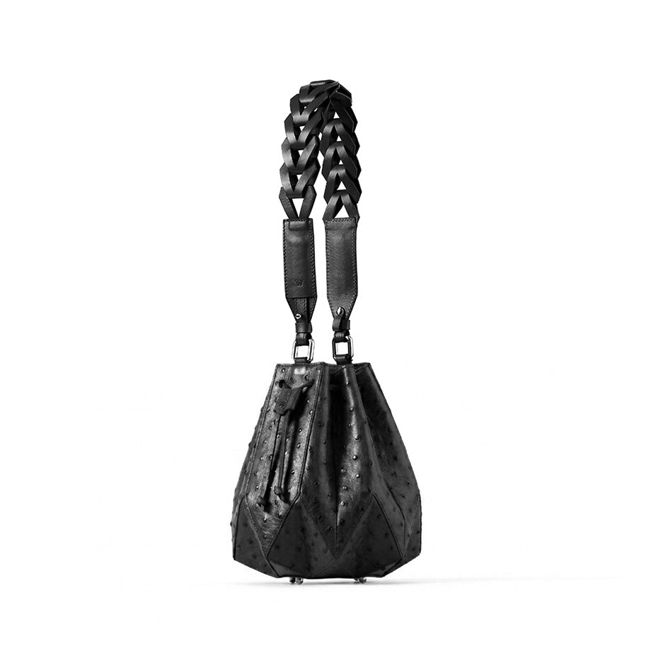 Black leather handbag with braided handle on a white background