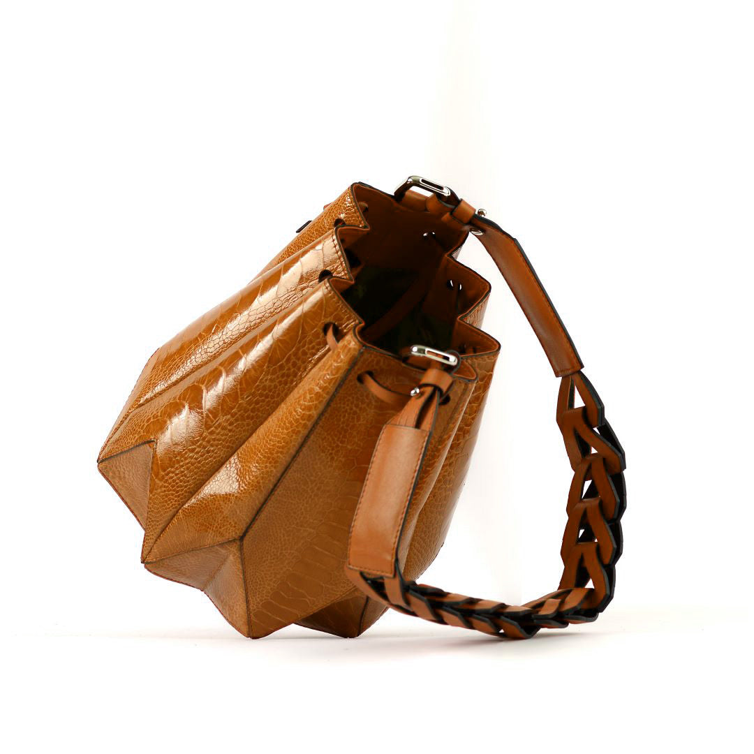 Red leather handbag with a braided handle on a white background