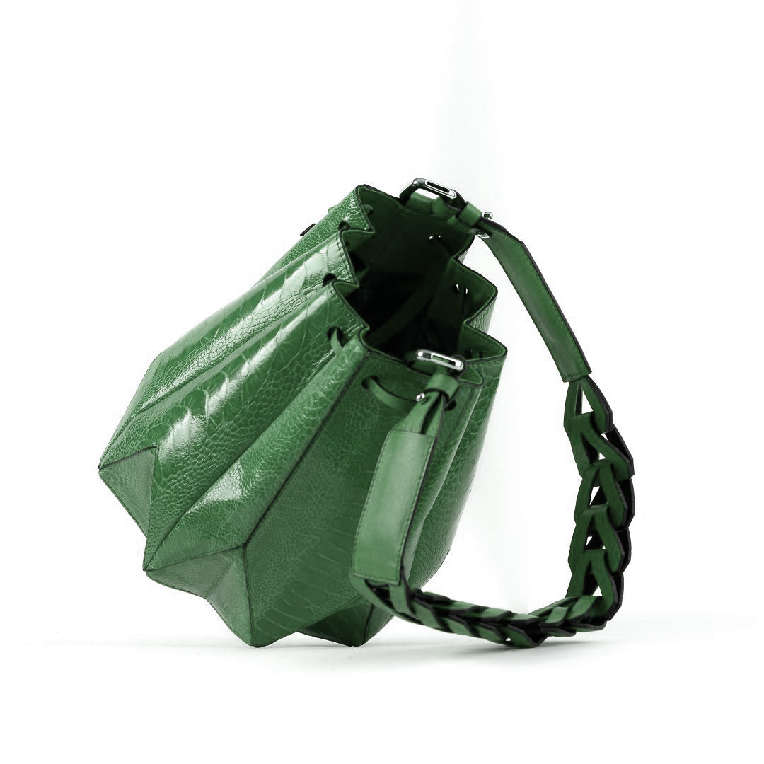 Green handbag with a braided handle on a white background