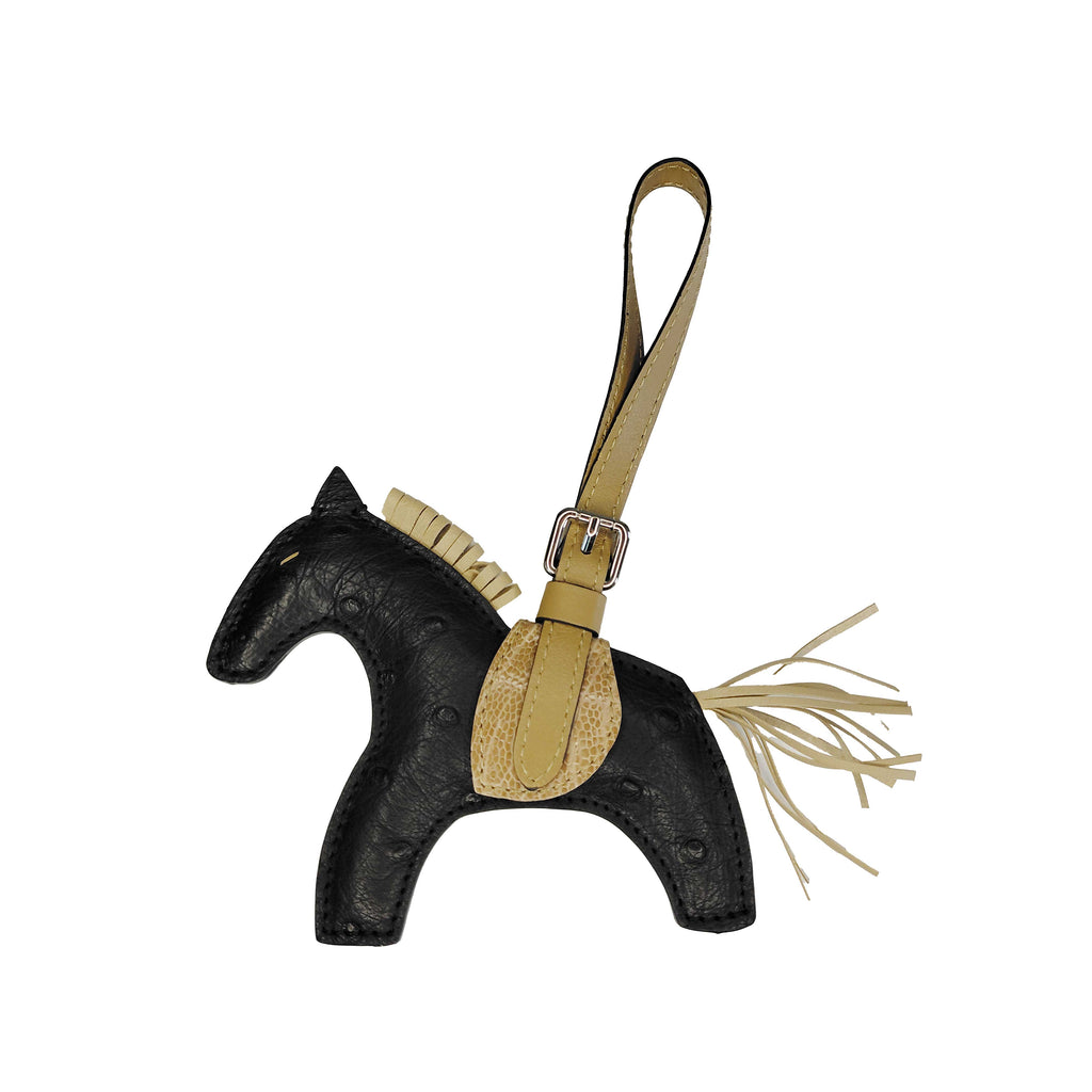 Horse-shaped keychain with black body and beige accents on a white background