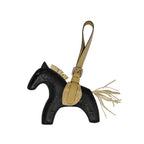 Horse-shaped keychain with black body and beige accents on a white background